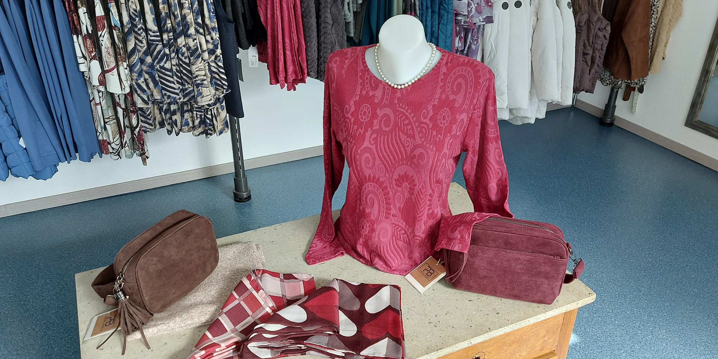 Rotes Oberteil mit passenden Taschen und Tüchern bei MODE Jörger